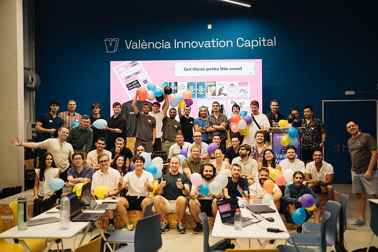 Group photo of hackathon participants with their balloons in front of the stage