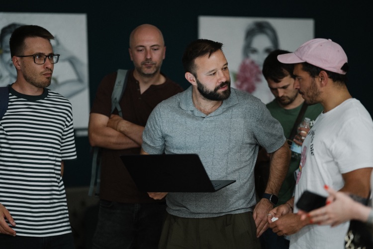 Attendees discussing a workflow around a laptop