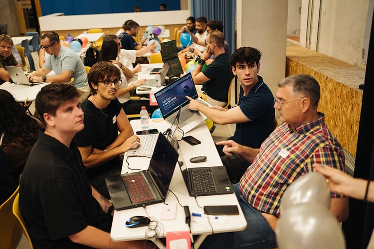 Participants discussing the “Ask Your Google Drive” challenge on a laptop